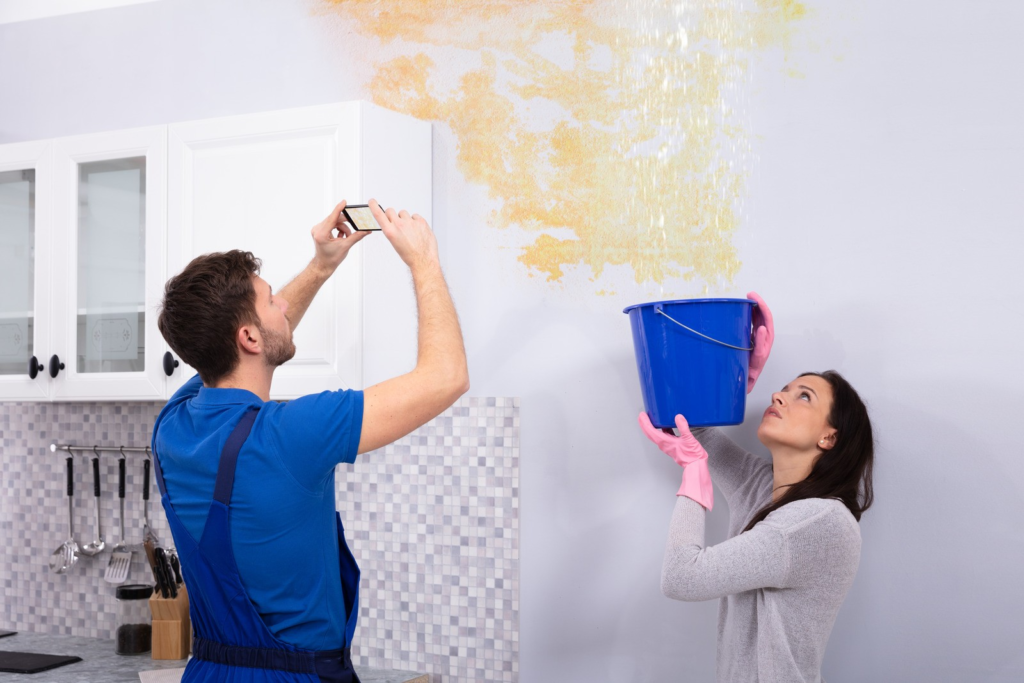 Man Taking Photo On Mobile Phone Of Water Damage